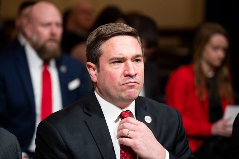 Missouri Attorney General Andrew Bailey adjusts his necktie while in a Congressional hearing room