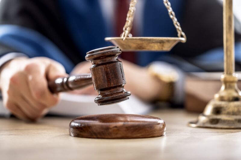 A judge banging a gavel next to a scale, representing justice