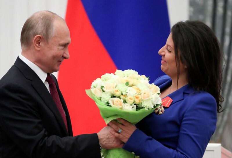 Russia President Vladimir Putin hands a bouquet of flowers to editor-in-chief of Russian broadcaster RT Margarita Simonyan.