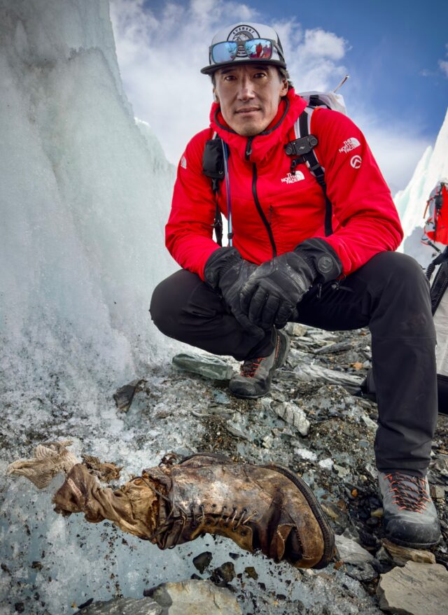 Jimmy Chin squatting next to old sock and book on a glacier