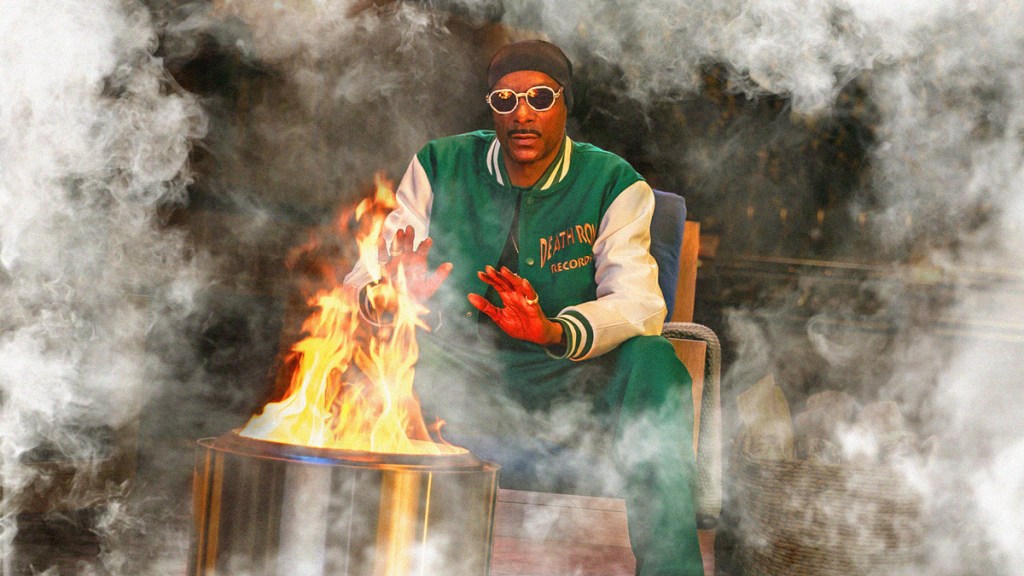 Snoop Dogg using a Solo Stove surrounded by smoke.