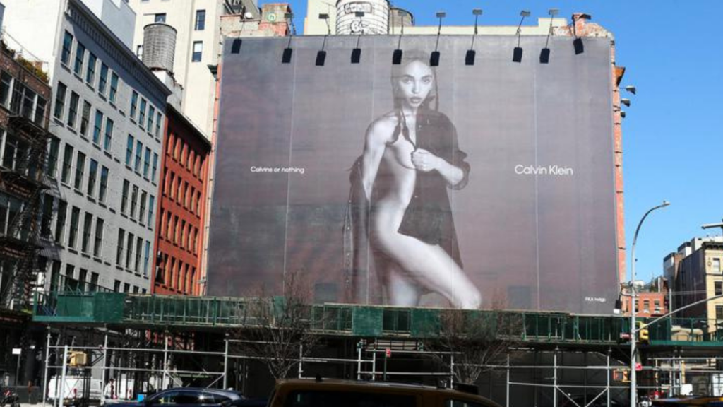 Billboard on the side of a building showing FKA twigs wearing a Calvin Klein shirt