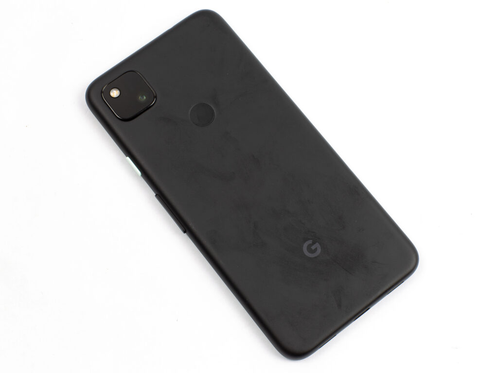 Pixel 4a, tilted, face down, with fingerprints across its back cover.