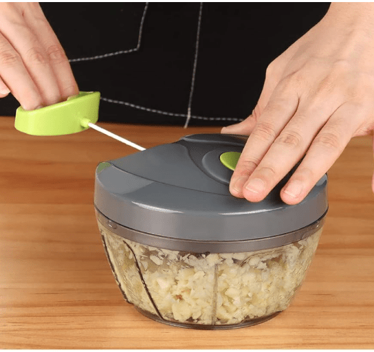 Hands of person putting blade into grey food chopper